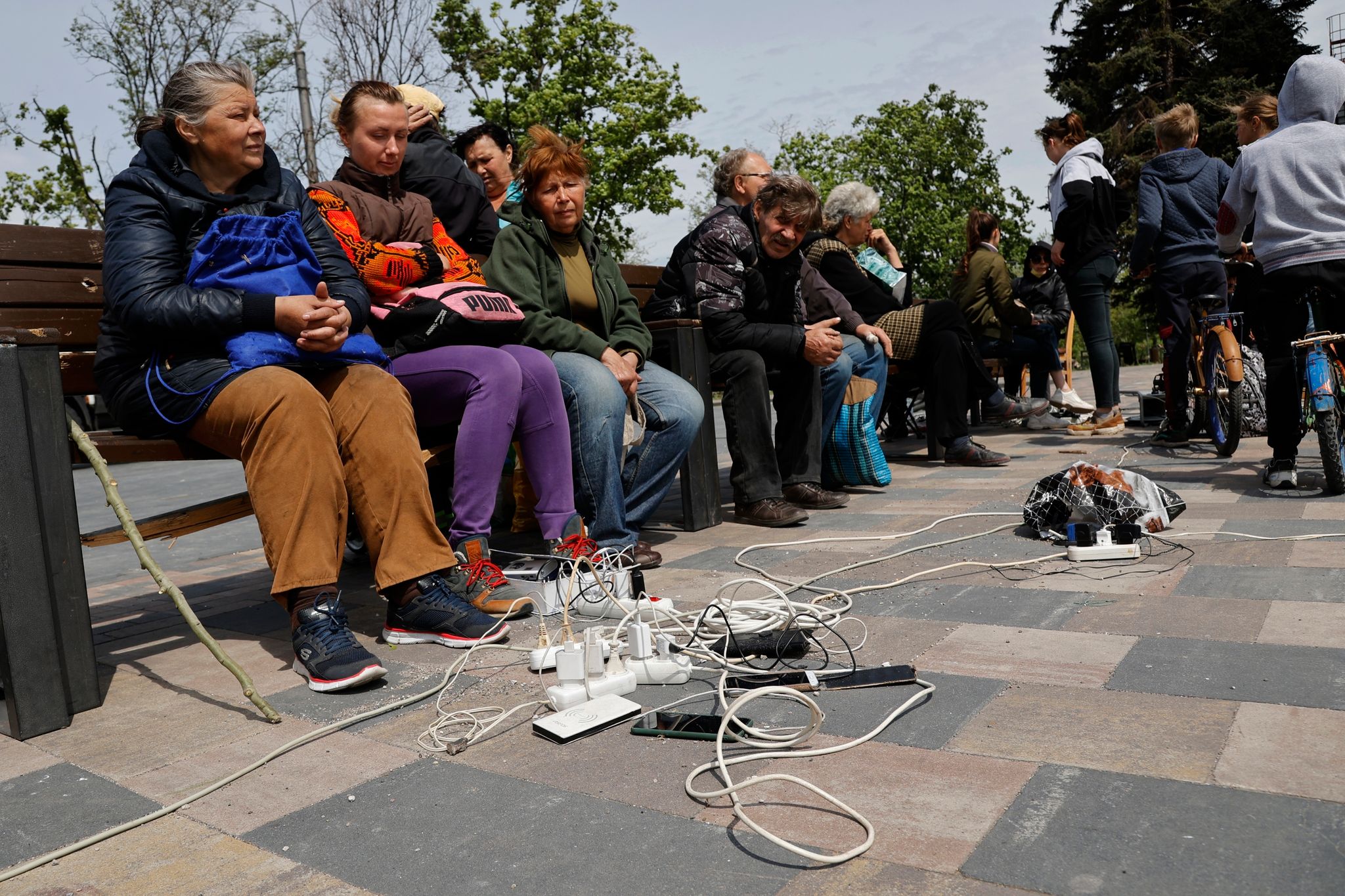 Menschen in Mariupol laden ihre Telefone auf - das Gebiet in der Ostukraine steht unter der Regierung der sogenannten Donezker Volksrepublik. (© Alexei Alexandrov/AP/dpa)