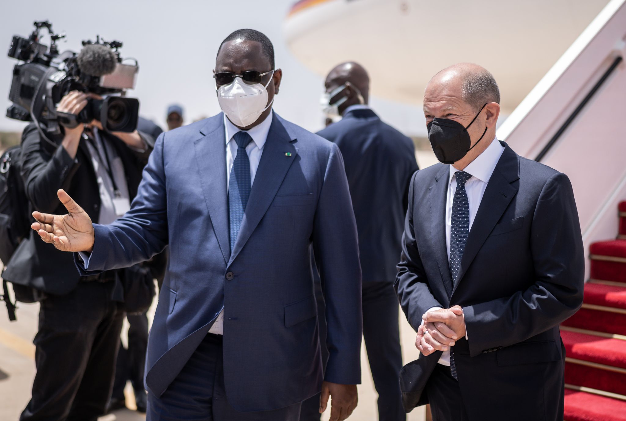 Bundeskanzler Olaf Scholz (r, SPD), wird von Macky Sall, Präsident der Republik Senegal mit militärischen Ehren am Flughafen begrüßt. (© Michael Kappeler/dpa)