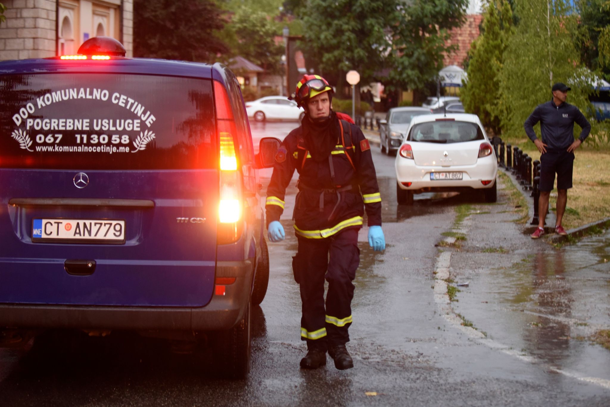 Ein Feuerwehrmann geht an einem Leichenwagen am Ort des Amoklaufs vorbei. (© Risto Bozovic/AP/dpa)