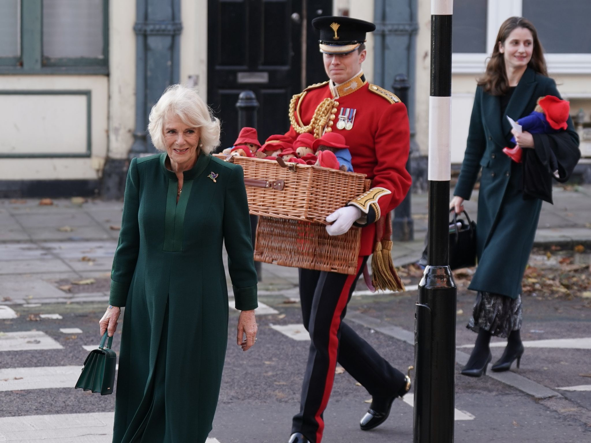 Königsgemahlin Camilla (l) bringt Paddington-Plüschtiere in die  Barnardo's-Kindertagesstätte in London. (© Yui Mok/PA Wire/dpa)