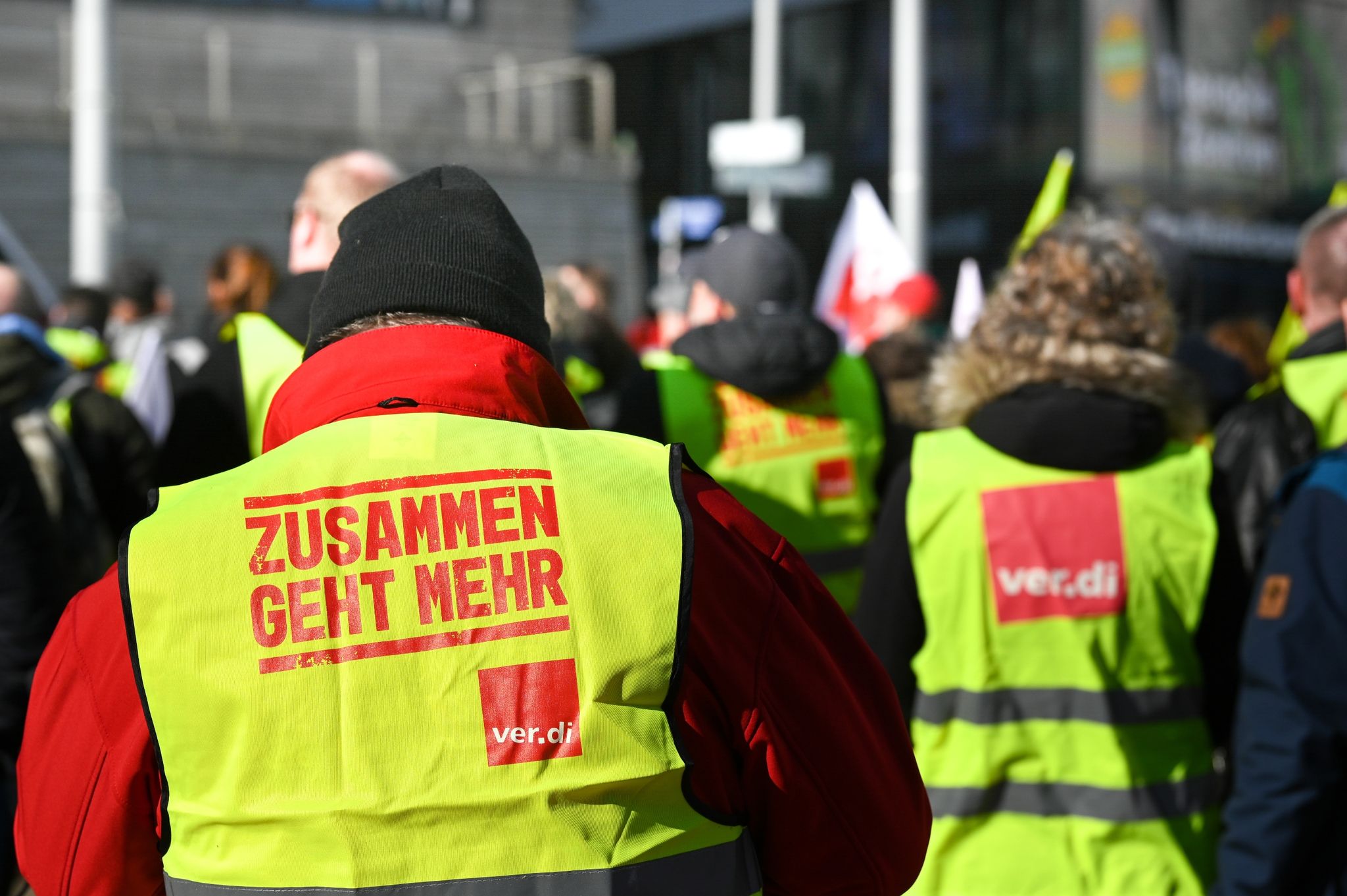 Kommunale Beschäftigte tragen bei einem Warnstreik während einer Kundgebung in Halle Westen der Gewerkschaft Verdi. (© Heiko Rebsch/dpa)