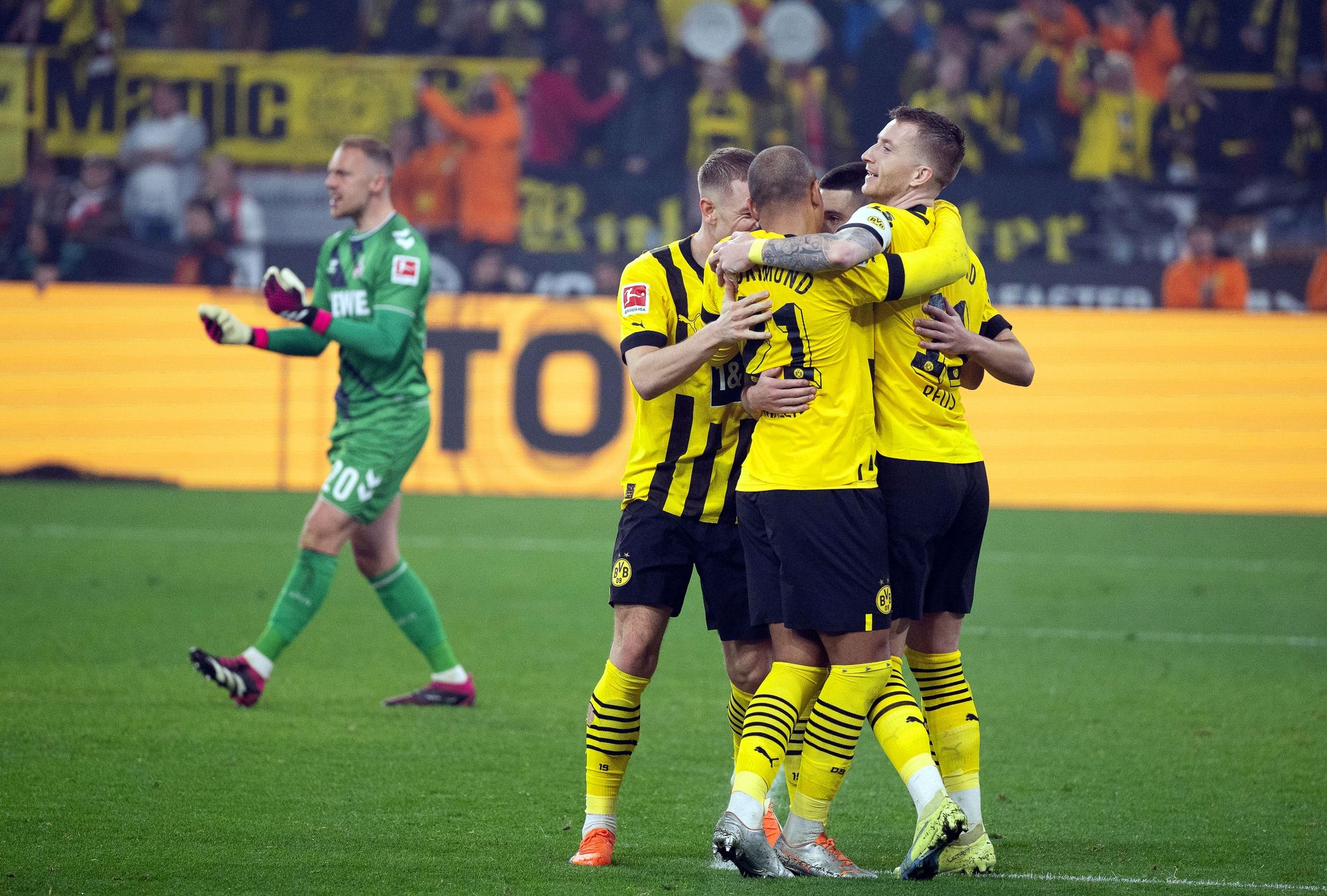 Dortmunds Marco Reus (r) jubelt mit den Teamkollegen über seinen Treffer zum 6:1. Hinten Kölns Torwart Marvin Schwäbe. (© Bernd Thissen/dpa)