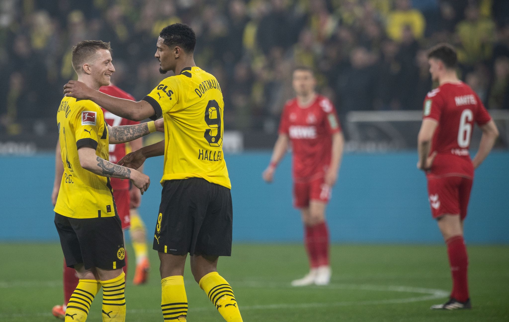 Dortmunds Sebastien Haller (r) gratuliert Marco Reus zu seinen beiden Treffern. (© Bernd Thissen/dpa)