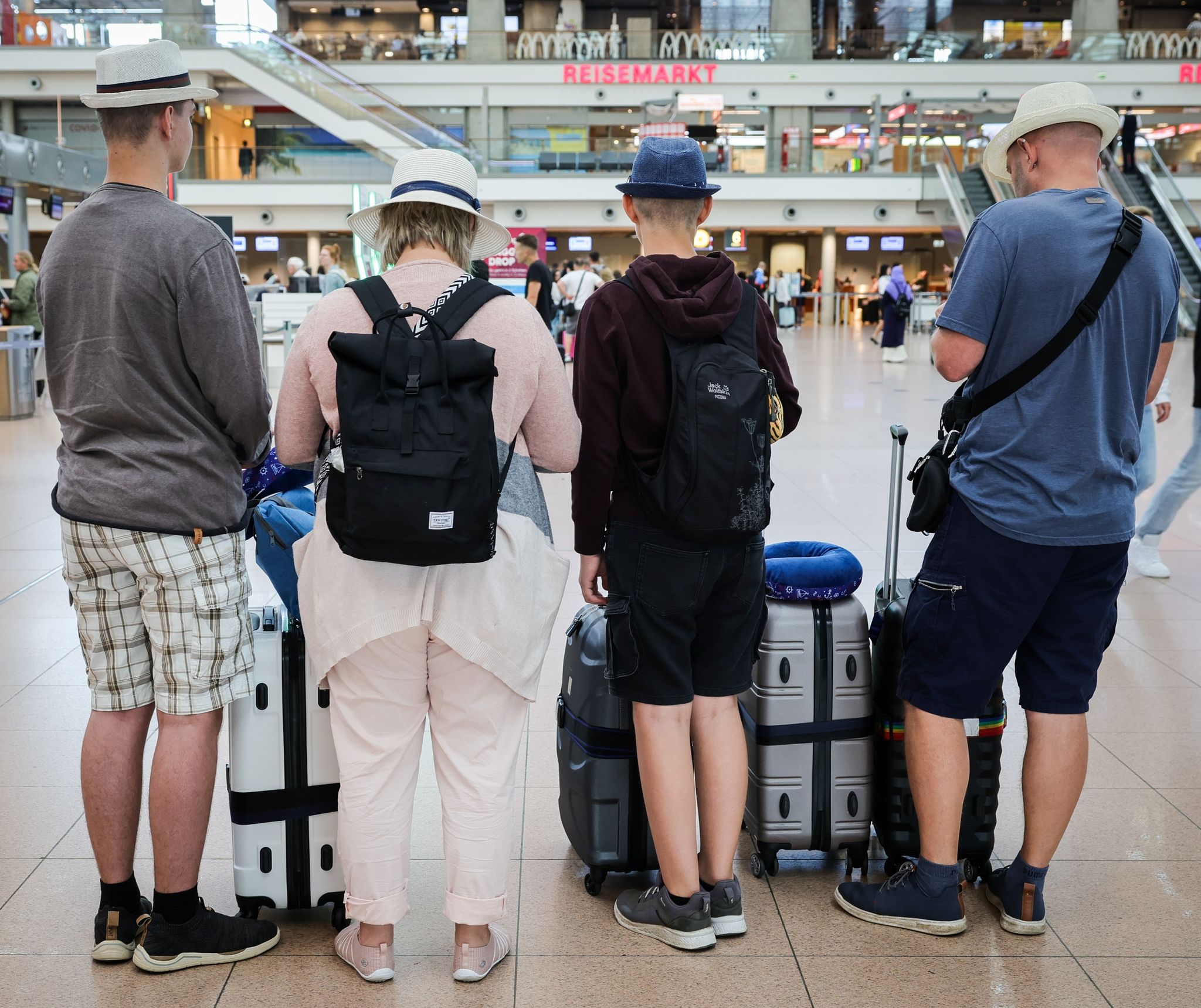 Familie am Flughafen Hamburg: Die Menschen fahren wieder häufiger ins Ausland und nutzen dafür auch eher wieder das Flugzeug, das in der Pandemie gemieden worden war. (© Christian Charisius/dpa)