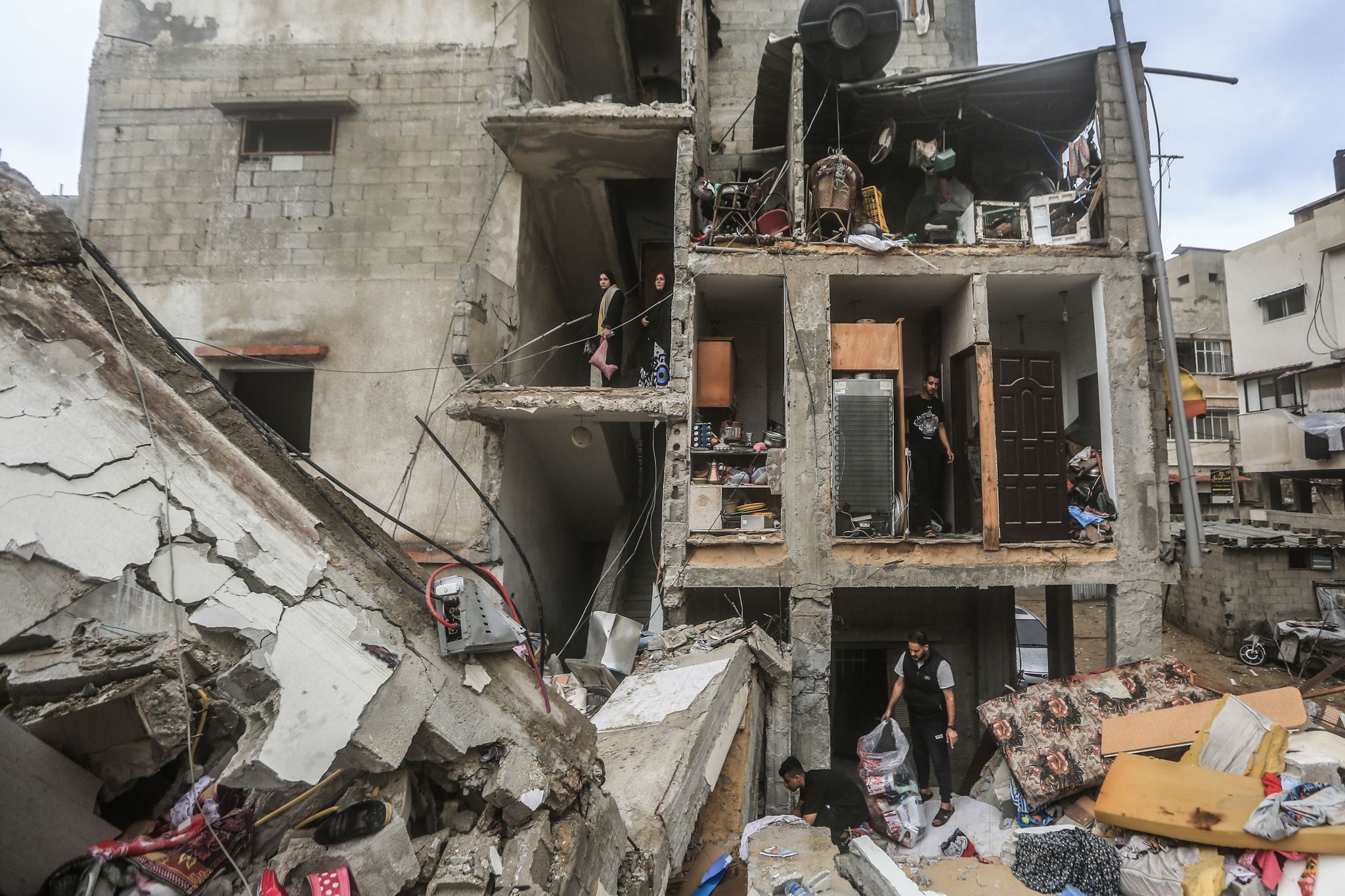 Palästinenser untersuchen die Trümmer zerstörter Gebäude nach einem israelischen Bombardement. (© Mohammed Talatene/dpa)
