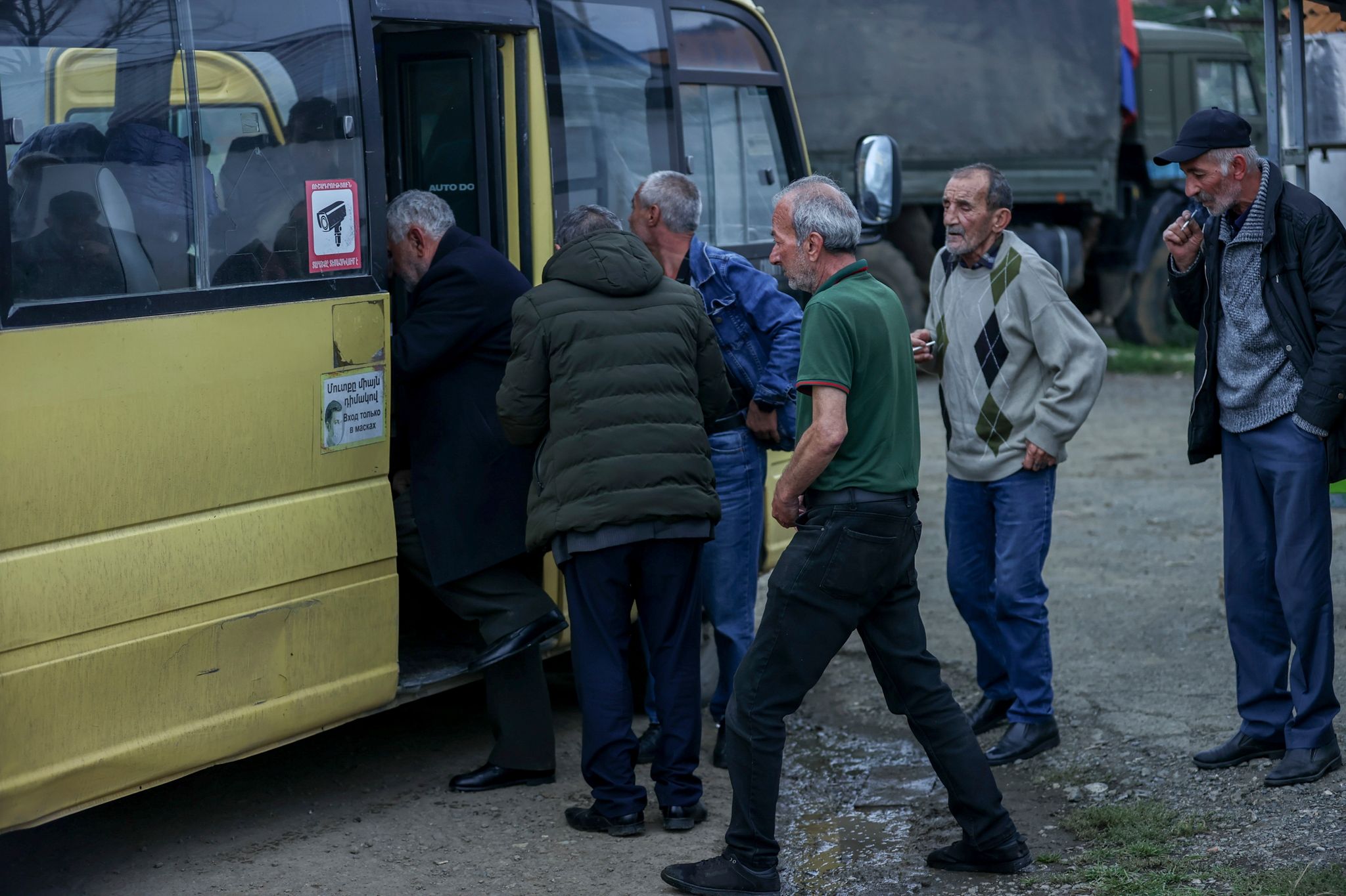 Ethnisch-armenische Männer steigen im Oktober in einen Bus nach Goris in Armenien ein. (© Aziz Karimov/AP/dpa)